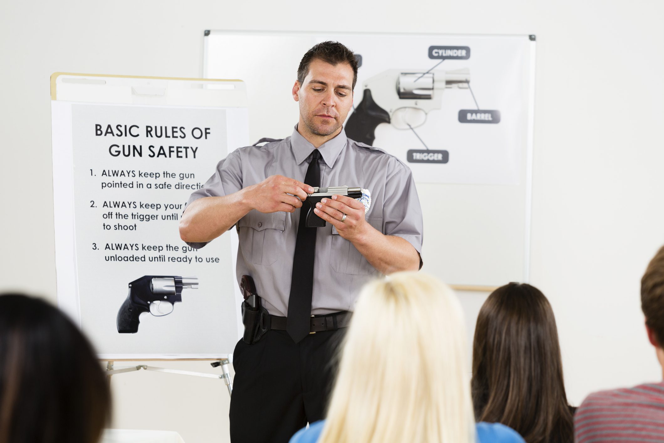 Gun safety class with instructor demonstrating.